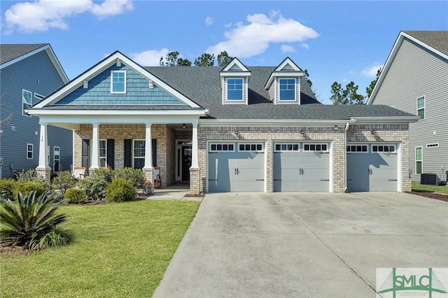 craftsman-style home with a garage, central AC, a front yard, and covered porch