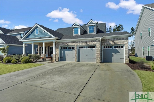 craftsman-style house featuring a garage, central AC, and a porch