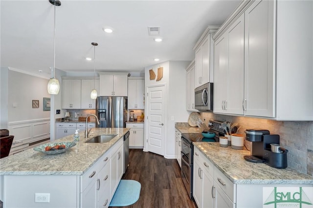 kitchen with stainless steel appliances, hanging light fixtures, sink, and white cabinets