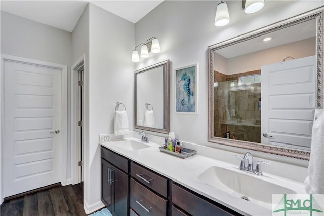 bathroom featuring vanity, an enclosed shower, and wood-type flooring