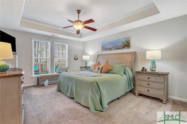 carpeted bedroom with ceiling fan, ornamental molding, and a tray ceiling