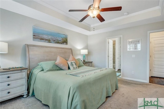 bedroom with ornamental molding, light carpet, ceiling fan, and a tray ceiling