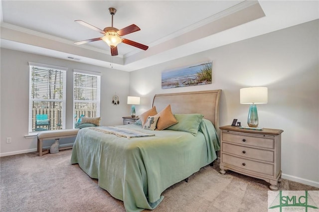 bedroom with ornamental molding, light colored carpet, a raised ceiling, and ceiling fan