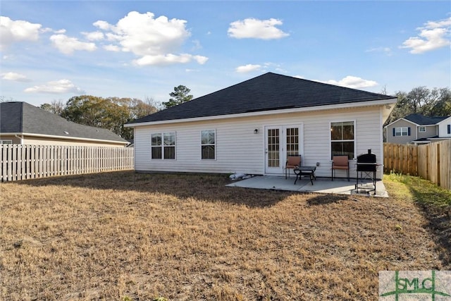 rear view of house with a yard, a patio area, and french doors