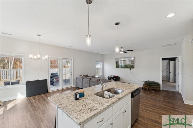 kitchen featuring sink, decorative light fixtures, dishwasher, an island with sink, and white cabinets