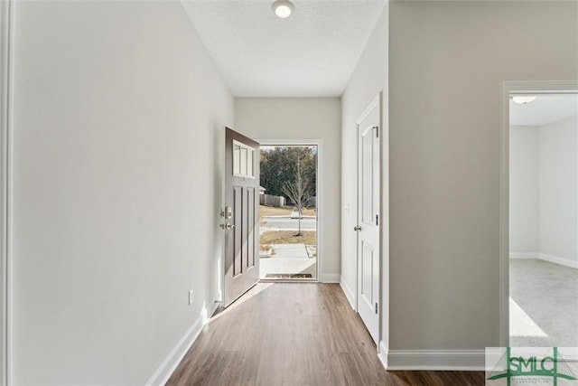 hallway featuring wood-type flooring and a textured ceiling