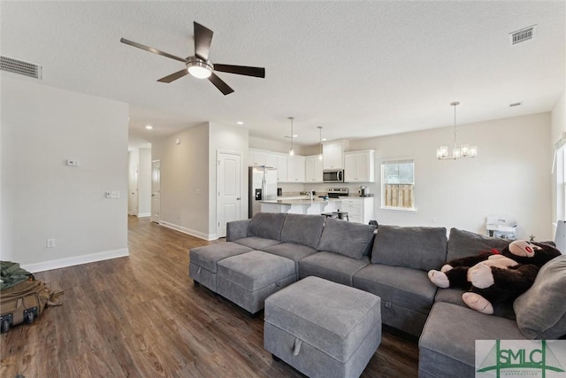 living room featuring sink, dark hardwood / wood-style floors, ceiling fan with notable chandelier, and a textured ceiling