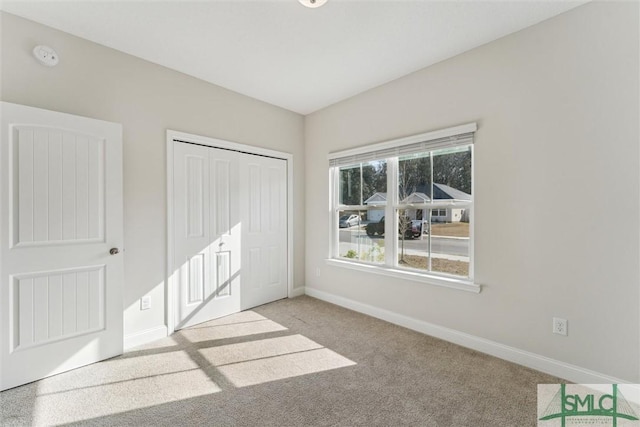 unfurnished bedroom with light carpet and a closet