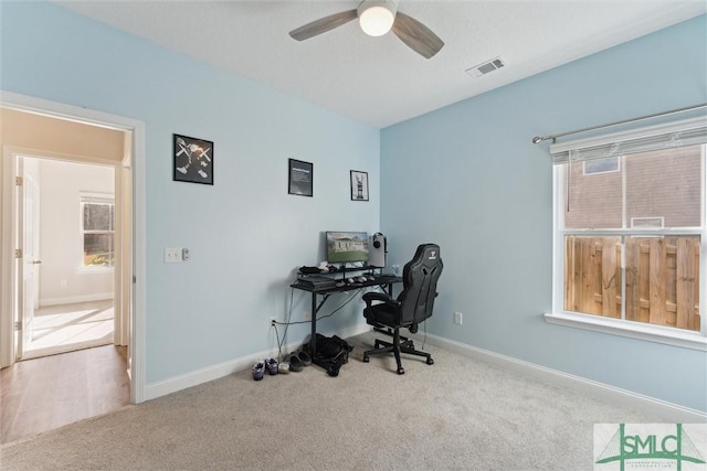 office space with light carpet and ceiling fan