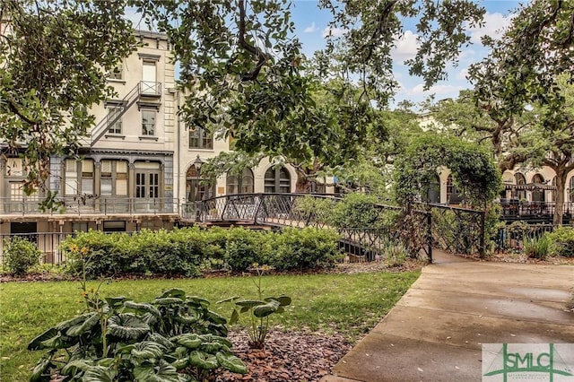 view of front facade featuring a front yard, fence, and stucco siding