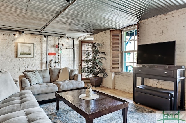 living room with brick wall and wood finished floors