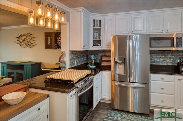 kitchen with white cabinetry, tasteful backsplash, appliances with stainless steel finishes, and hanging light fixtures