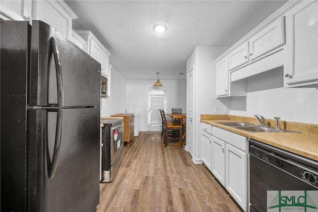 kitchen with white cabinetry, decorative light fixtures, sink, and black appliances