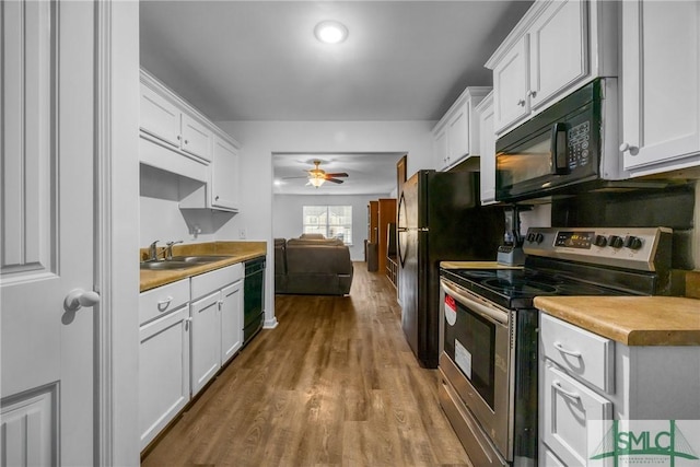 kitchen featuring sink, ceiling fan, black appliances, light hardwood / wood-style floors, and white cabinets