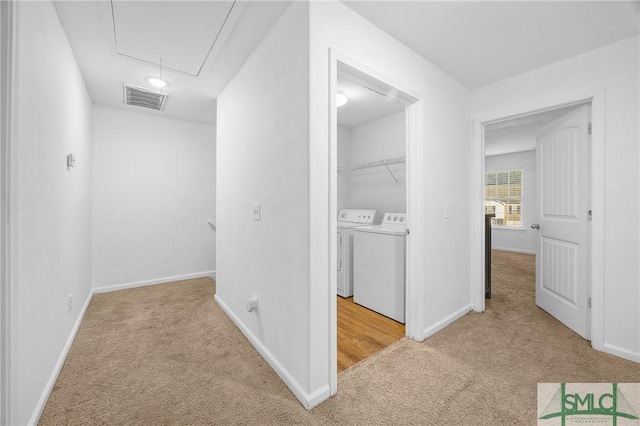 hall featuring light carpet and washer and dryer