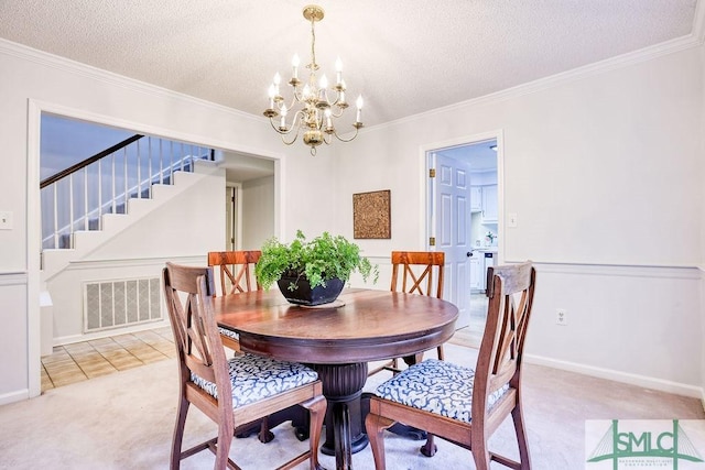 carpeted dining area featuring ornamental molding, an inviting chandelier, and a textured ceiling