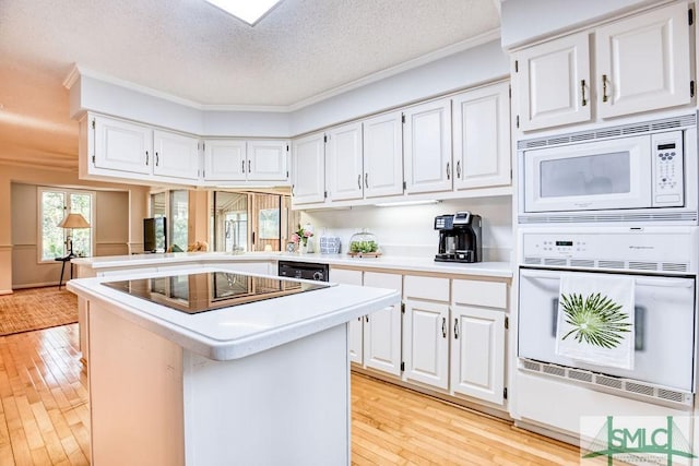 kitchen featuring black appliances, a center island, and white cabinets