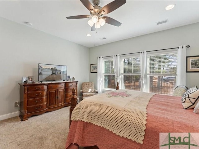 carpeted bedroom featuring multiple windows and ceiling fan