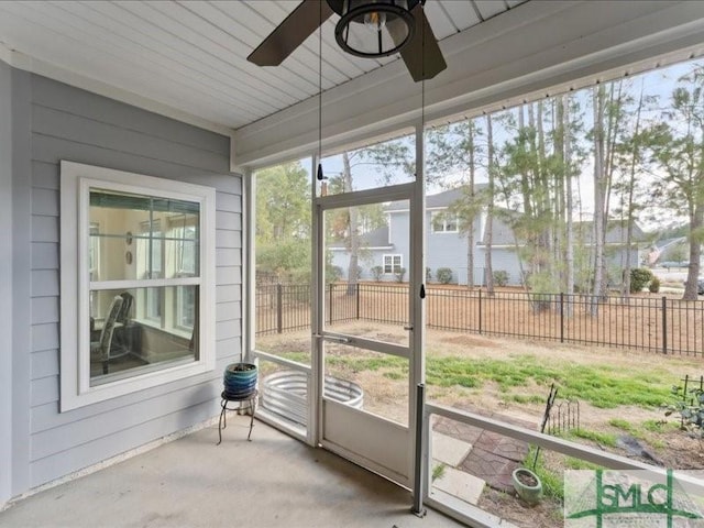 unfurnished sunroom featuring ceiling fan