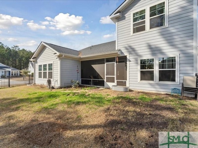 back of property featuring a lawn and a sunroom