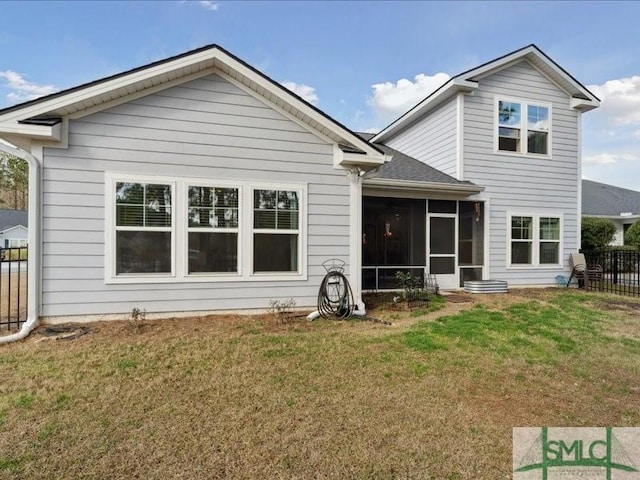 back of house with a yard and a sunroom