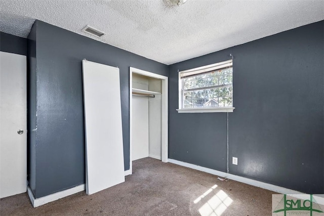 unfurnished bedroom with a closet, a textured ceiling, and carpet