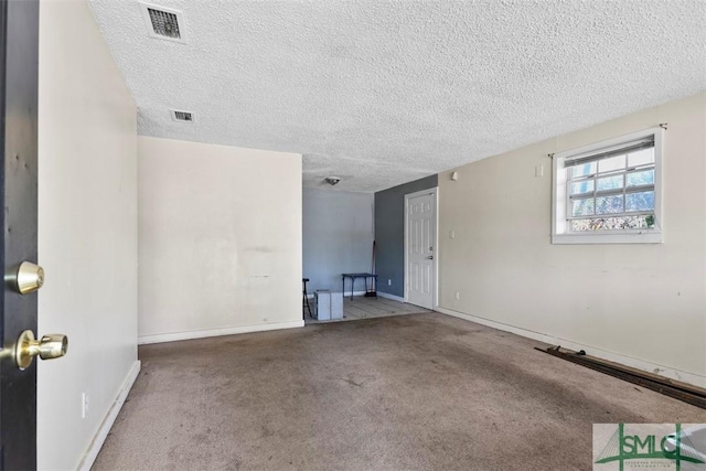 carpeted spare room featuring a textured ceiling