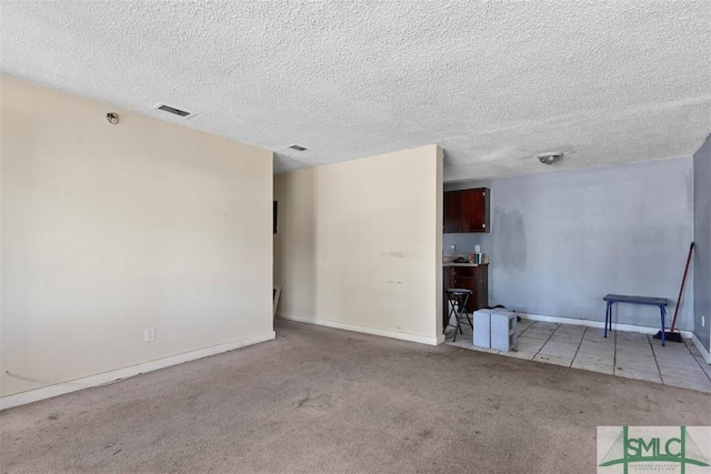 carpeted empty room with a textured ceiling