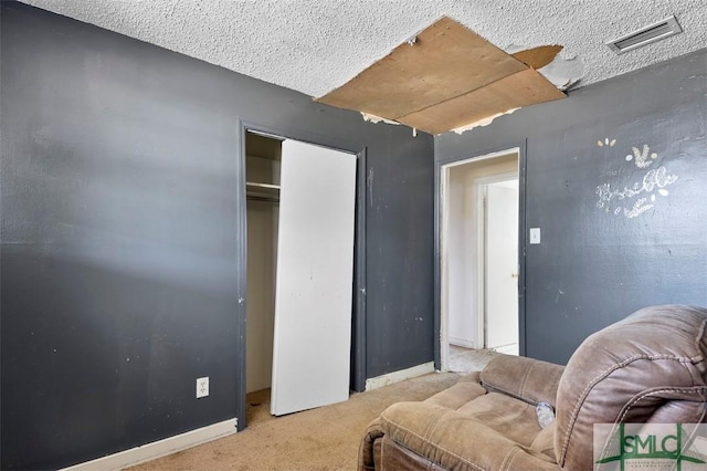 sitting room with light colored carpet and a textured ceiling