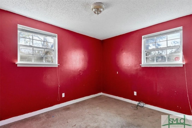 carpeted empty room with a textured ceiling