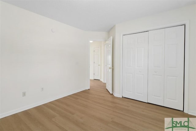 unfurnished bedroom featuring a closet and light wood-type flooring