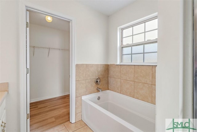 bathroom featuring tile patterned flooring and a bath