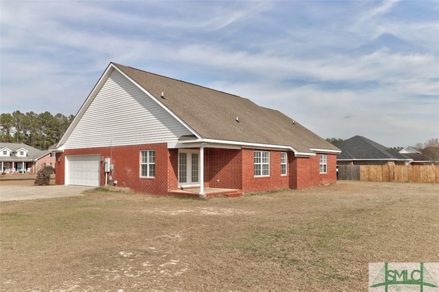 back of property featuring a garage and a yard