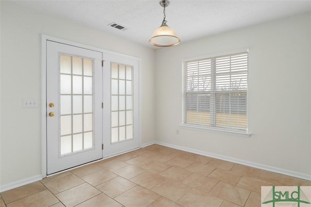 doorway to outside with a textured ceiling