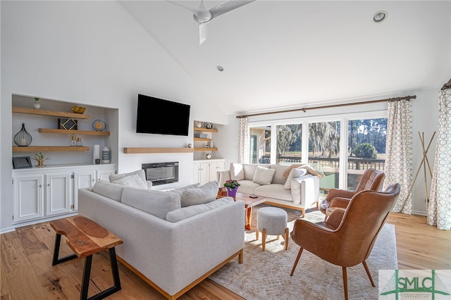 living room with high vaulted ceiling and light wood-type flooring