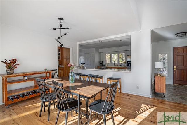 dining area featuring light hardwood / wood-style flooring and ornamental molding