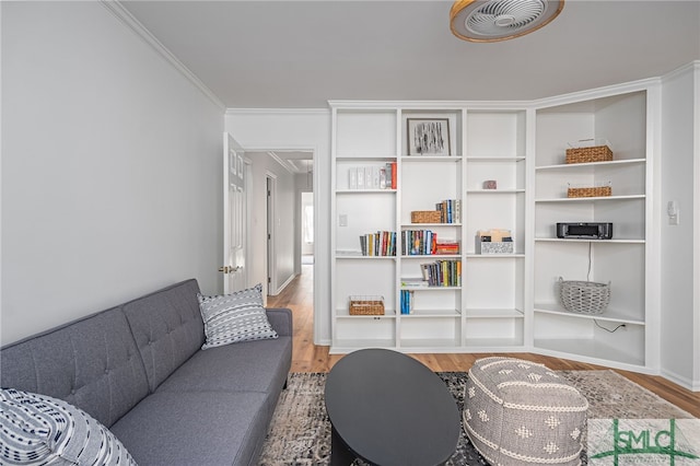 living area featuring crown molding and hardwood / wood-style flooring