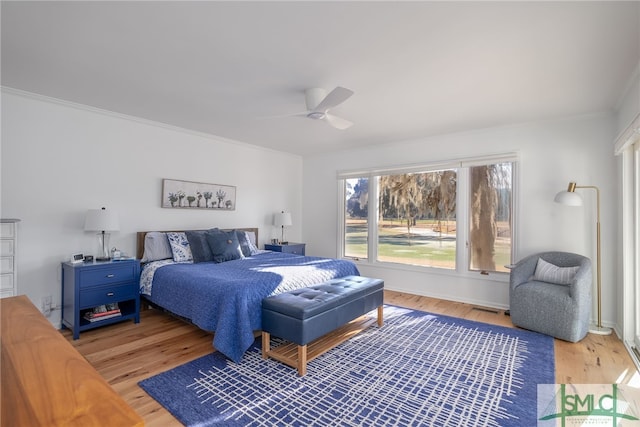 bedroom with wood-type flooring, ornamental molding, and ceiling fan