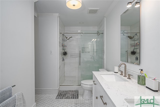 bathroom featuring vanity, ornamental molding, toilet, a shower with door, and tile patterned floors