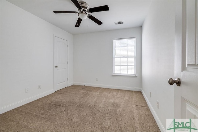 spare room with ceiling fan and carpet