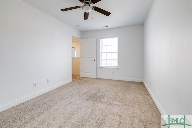 interior space with light carpet, a ceiling fan, visible vents, and baseboards