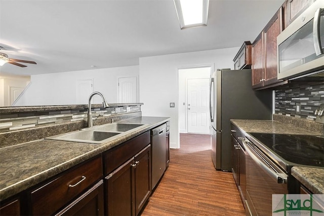 kitchen with decorative backsplash, a ceiling fan, dark wood-style flooring, stainless steel appliances, and a sink