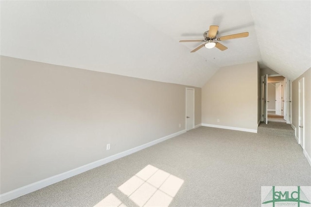 bonus room with vaulted ceiling, light colored carpet, and ceiling fan