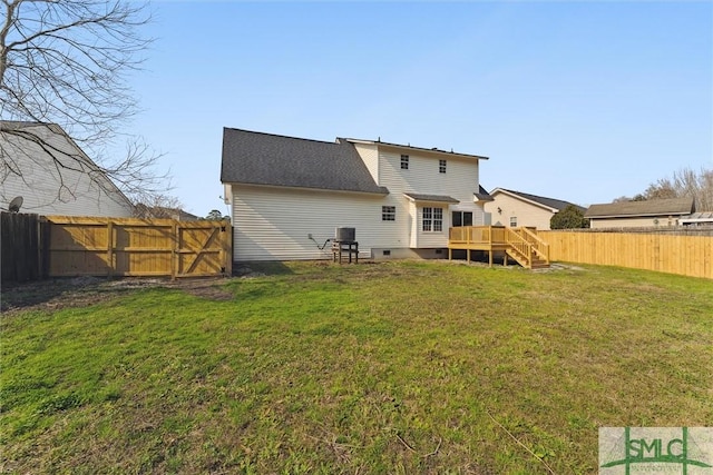 rear view of house with a wooden deck, cooling unit, and a lawn