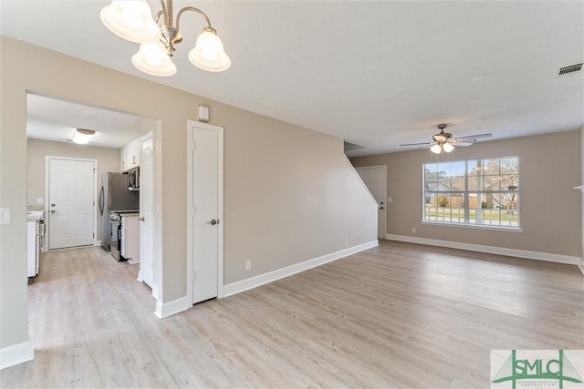 unfurnished living room featuring ceiling fan with notable chandelier and light wood-type flooring