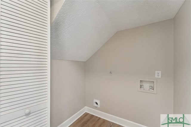 laundry room with hookup for a washing machine, wood-type flooring, hookup for an electric dryer, and a textured ceiling