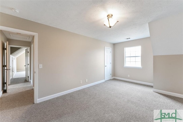 carpeted spare room featuring a textured ceiling