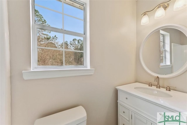 bathroom featuring vanity, plenty of natural light, and toilet