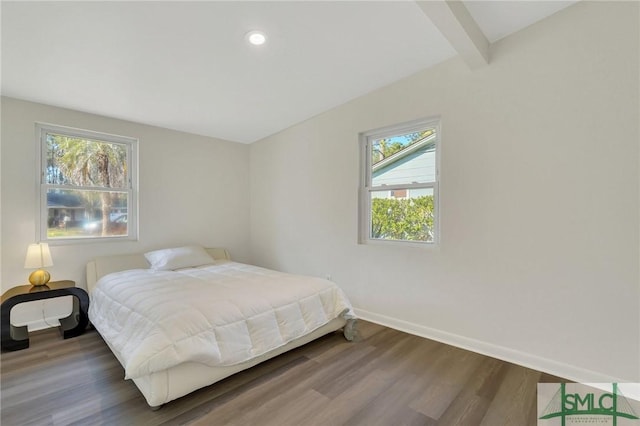 bedroom featuring hardwood / wood-style flooring and beam ceiling