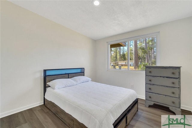 bedroom with hardwood / wood-style flooring and a textured ceiling